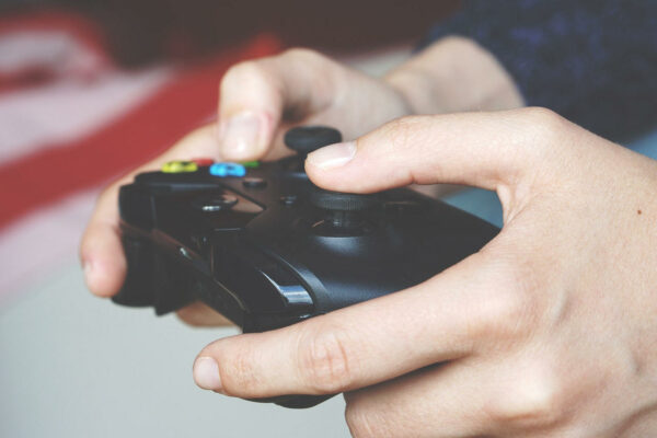 Man hält schwarzen Gamecontroller