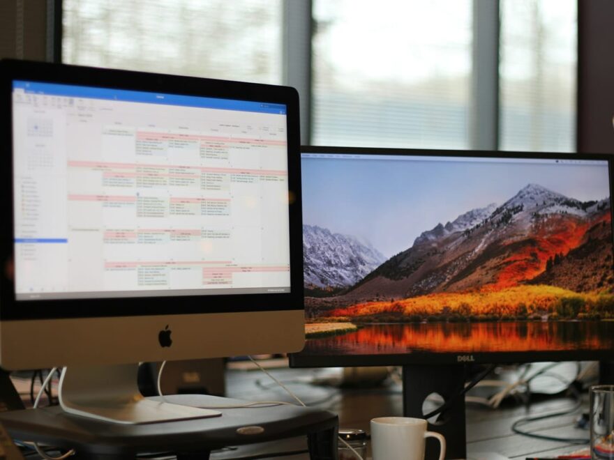 Zwei Bildschirme nebeneinander: Einer zeigt einen Kalender, der andere eine Landschaft, ideal für produktives Arbeiten.