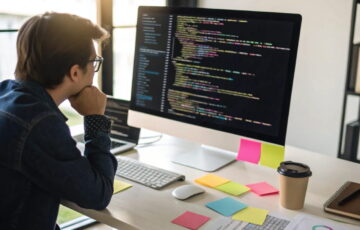 Programmierer beim Debugging, analysiert Code mit Highlight auf Fehler.