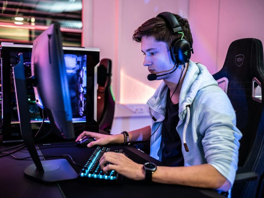 Gamer mit Headset vor einem Monitor, Blaulichtfilter für Augenschutz