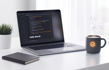 Laptop mit Python-Code und Python-Logo auf einem Schreibtisch, ideal für Einsteiger in die Programmierung.