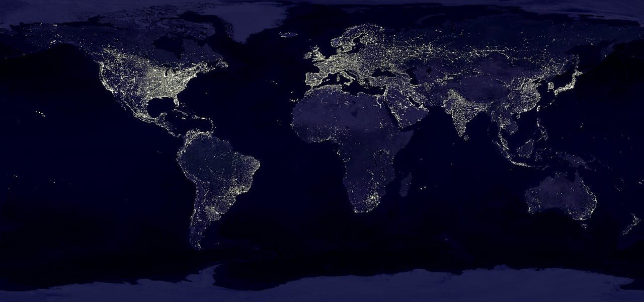 Weltkarte bei Nacht mit globaler Vernetzung – Auswirkungen des AI Act auf internationale KI-Dienste.