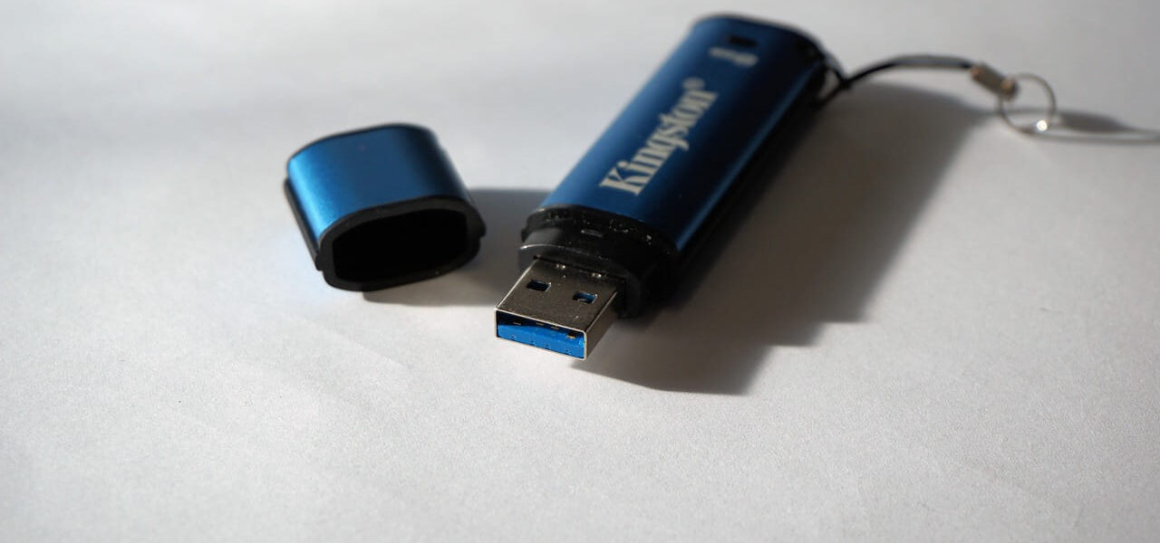Blauer USB-Stick mit abgenommener Schutzkappe auf weißem Hintergrund