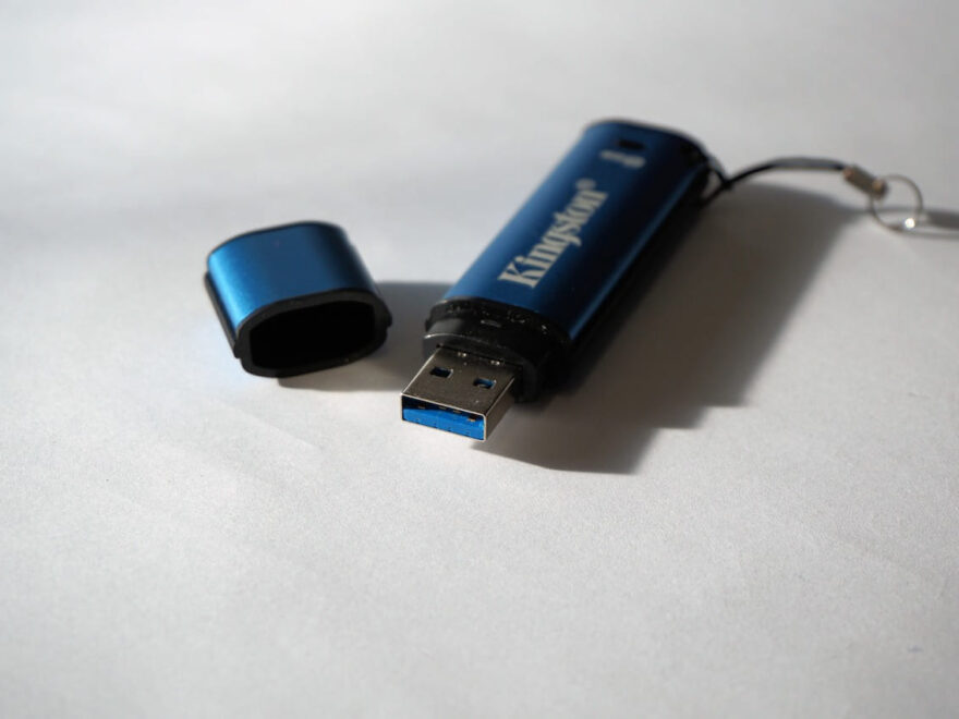Blauer USB-Stick mit abgenommener Schutzkappe auf weißem Hintergrund