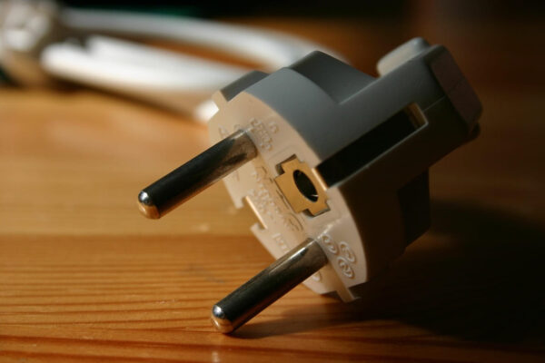Netzstecker in Weiß – sichere Stromversorgung im Alltag Weißer Netzstecker auf Holztisch – robust und sicher für den Anschluss von Geräten im Haushalt oder Büro