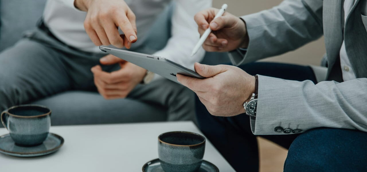 IT-Dienstleister berät Unternehmen mit Tablet am Tisch