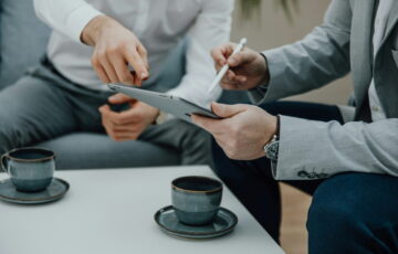 IT-Dienstleister berät Unternehmen mit Tablet am Tisch