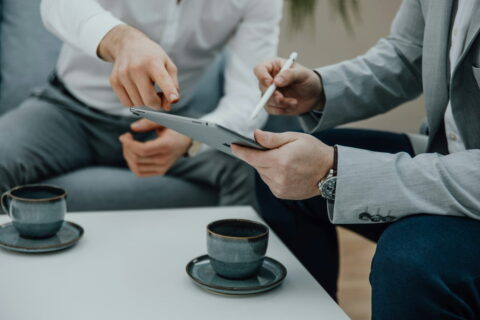 IT-Dienstleister berät Unternehmen mit Tablet am Tisch