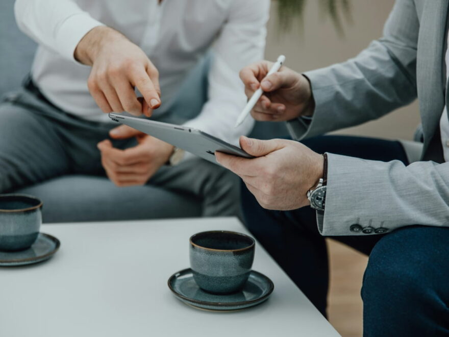 IT-Dienstleister berät Unternehmen mit Tablet am Tisch