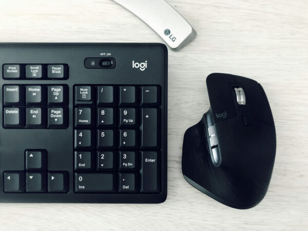 Kabellose Logitech Tastatur und Maus als komfortable Eingabegeräte im Homeoffice Logitech Tastatur und ergonomische Maus im Homeoffice auf hellem Schreibtisch