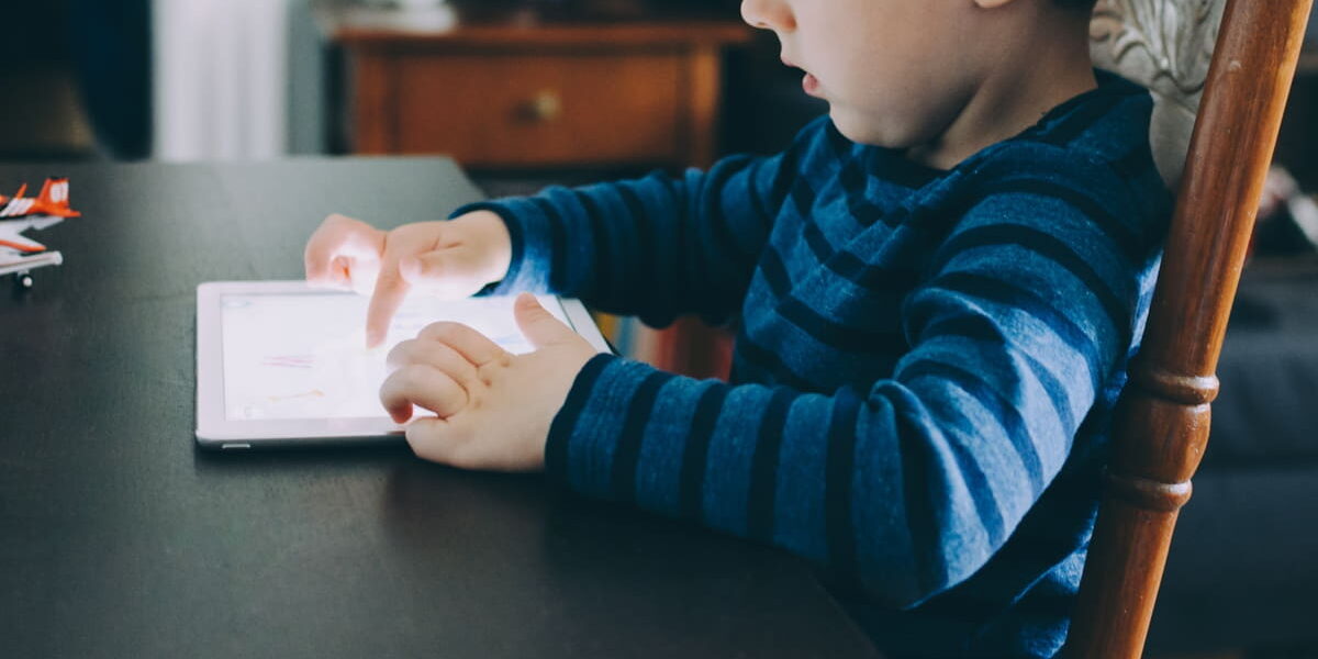 Kind nutzt Tablet – Symbolbild für Bildschirmzeit im Alltag
