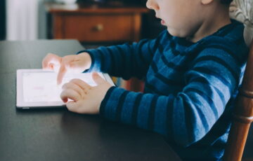 Kind nutzt Tablet – Symbolbild für Bildschirmzeit im Alltag