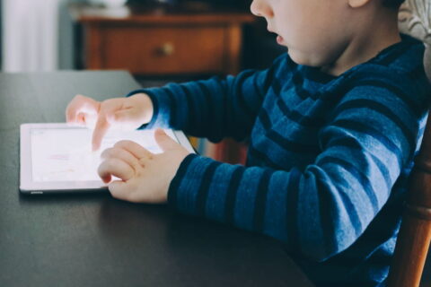 Kind nutzt Tablet – Symbolbild für Bildschirmzeit im Alltag