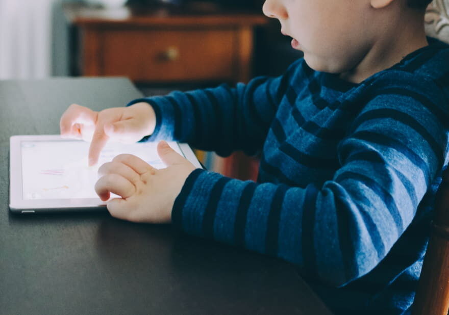 Kind nutzt Tablet – Symbolbild für Bildschirmzeit im Alltag