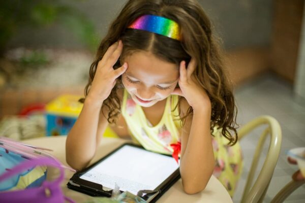 Kind bei Tablet-Nutzung – Bildschirmzeit sinnvoll begleiten Mädchen mit Tablet – Bildschirmzeit im Kindesalter beobachten