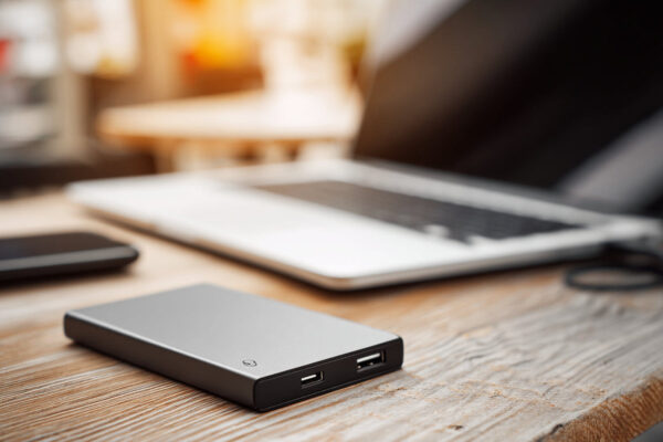 Externe SSD auf einem Schreibtisch neben einem Laptop zur Darstellung der Vorteile moderner SSDs.