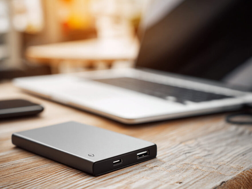 Externe SSD auf einem Schreibtisch neben einem Laptop zur Darstellung der Vorteile moderner SSDs.