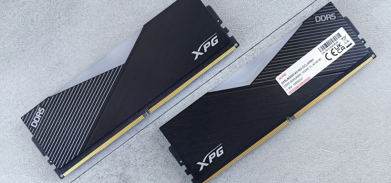 Zwei schwarze XPG DDR5 Arbeitsspeicher Module auf grauem Untergrund.