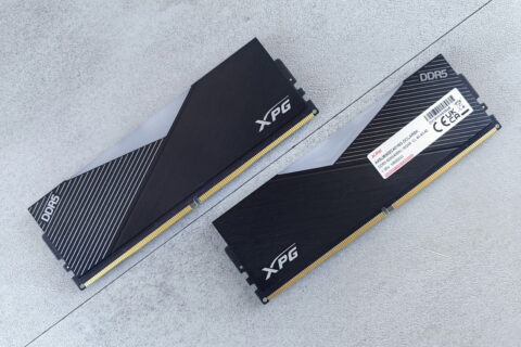 Zwei schwarze XPG DDR5 Arbeitsspeicher Module auf grauem Untergrund.