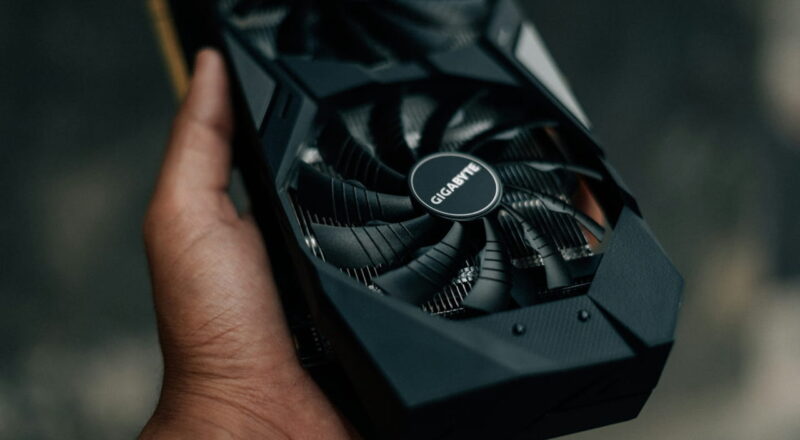 Moderne Gigabyte Grafikkarte mit zwei Lüftern in der Hand gehalten