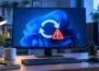 Windows 11 mit Neustart-Symbol und Warnhinweis auf einem PC-Monitor